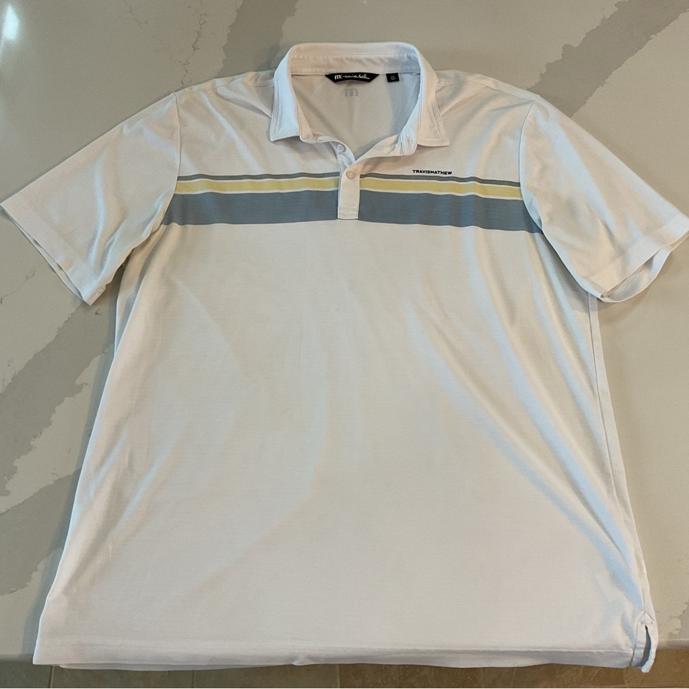 Men’s Travis Matthew polo shirt. White with blue/yellow chest stripe. Size XXL